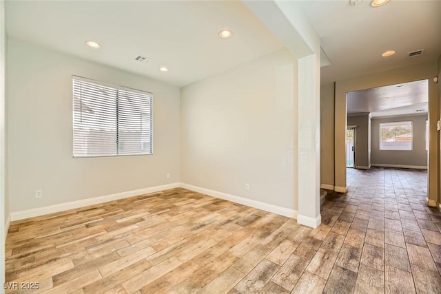 unfurnished room featuring baseboards and light wood finished floors