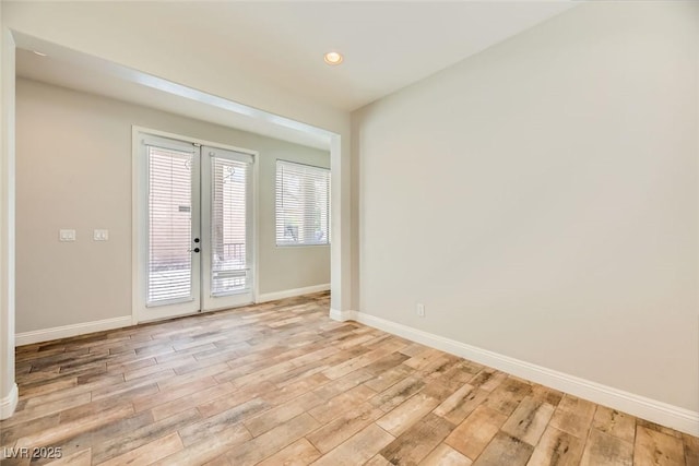 empty room with recessed lighting, french doors, baseboards, and wood finished floors