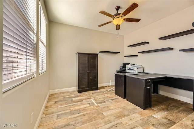 home office with a ceiling fan, light wood-style floors, and baseboards