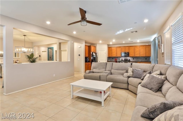 living area with visible vents, baseboards, light tile patterned floors, recessed lighting, and ceiling fan with notable chandelier