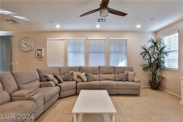 living area with light tile patterned floors, a ceiling fan, and visible vents