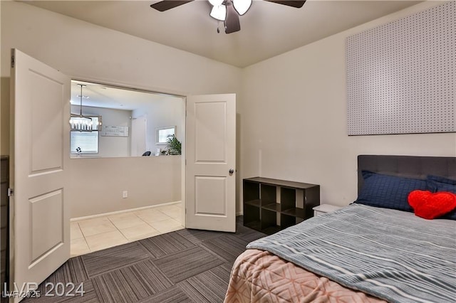 bedroom featuring ceiling fan with notable chandelier and carpet floors