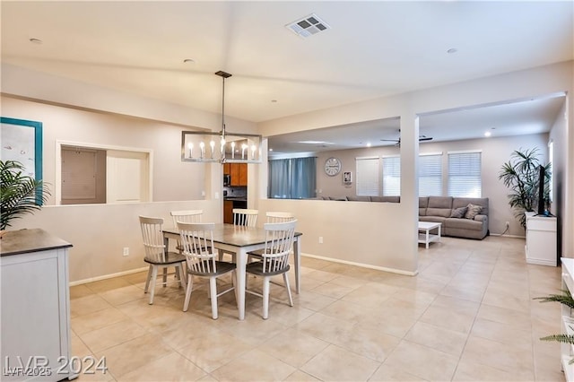 dining area featuring ceiling fan with notable chandelier, light tile patterned floors, baseboards, and visible vents