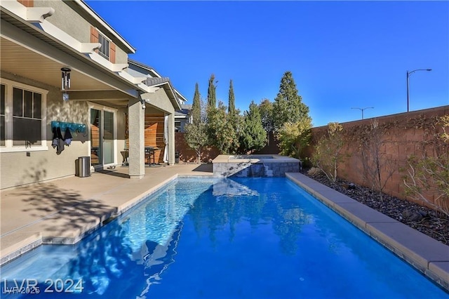 view of swimming pool with a patio, a pool with connected hot tub, and a fenced backyard