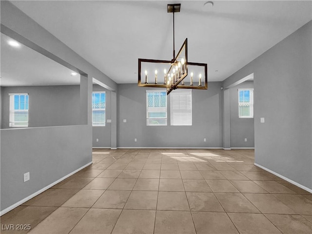 tiled spare room featuring baseboards