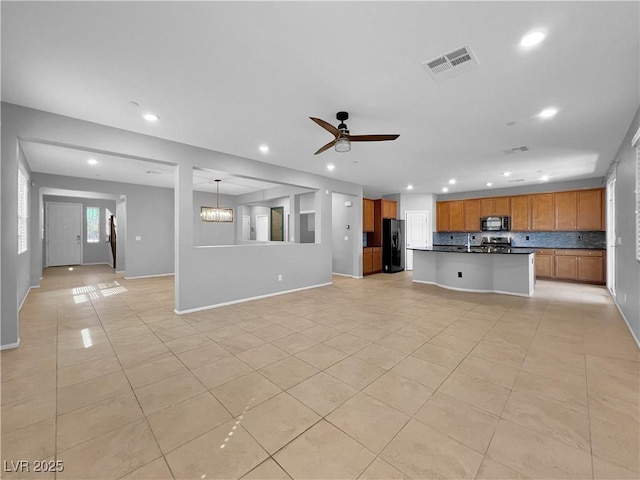 unfurnished living room with light tile patterned floors, visible vents, recessed lighting, and ceiling fan with notable chandelier