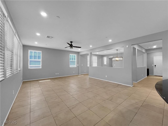 unfurnished living room with visible vents, baseboards, and ceiling fan with notable chandelier