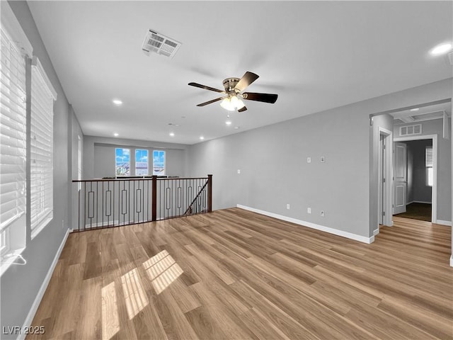 unfurnished room featuring baseboards, visible vents, and light wood finished floors