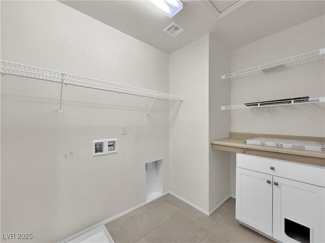 clothes washing area with visible vents, baseboards, washer hookup, light tile patterned floors, and cabinet space