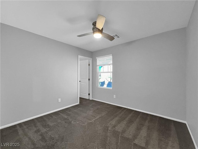 unfurnished room with baseboards, visible vents, dark carpet, and ceiling fan