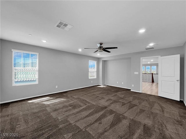 carpeted spare room with plenty of natural light, baseboards, and visible vents