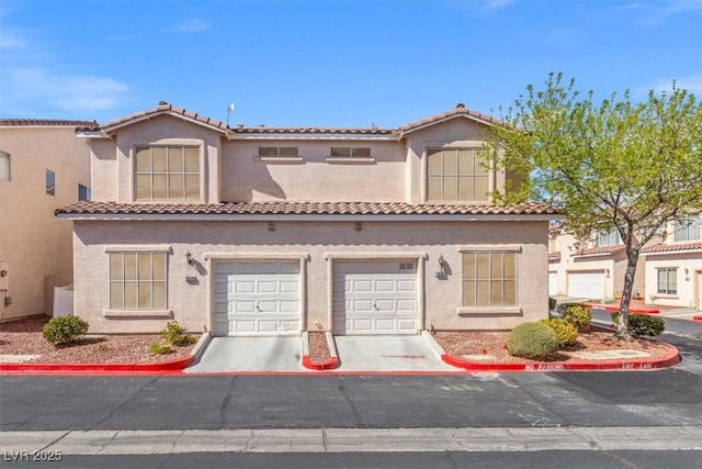 view of front of house with stucco siding, concrete driveway, an attached garage, and a tiled roof