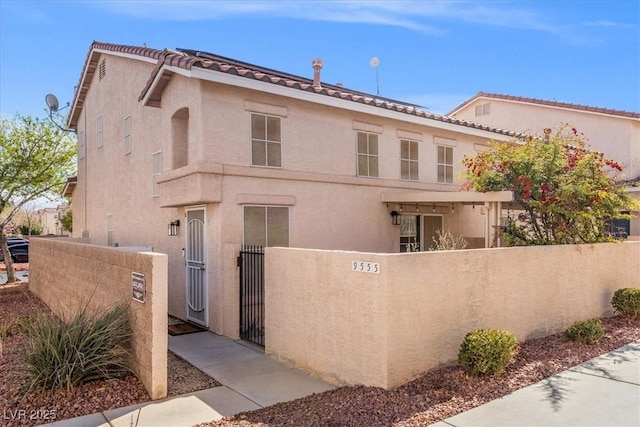 view of front of home with a gate, a fenced front yard, and stucco siding