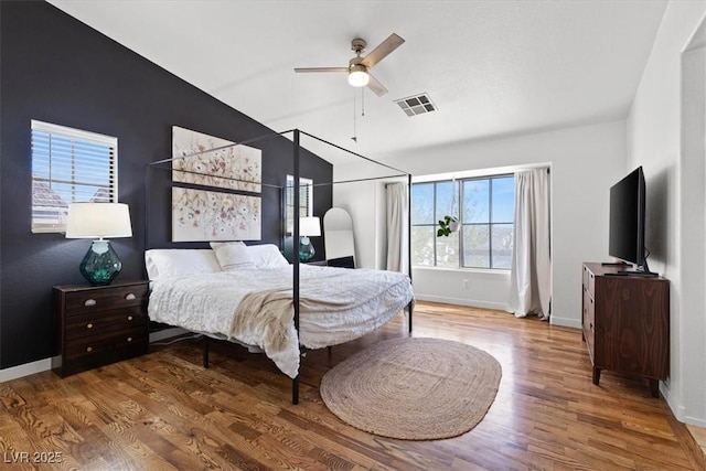 bedroom featuring visible vents, baseboards, and wood finished floors