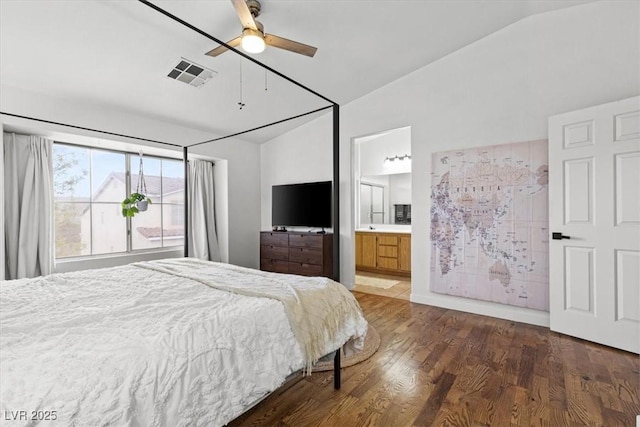 bedroom featuring ensuite bath, lofted ceiling, wood finished floors, and visible vents