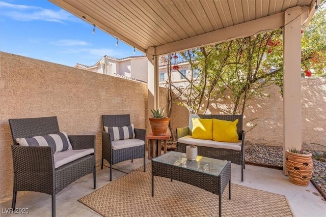 view of patio with an outdoor living space and fence