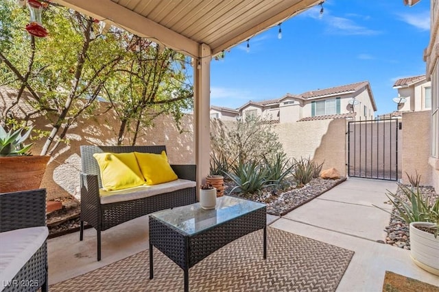 view of patio / terrace with an outdoor living space, fence, and a gate