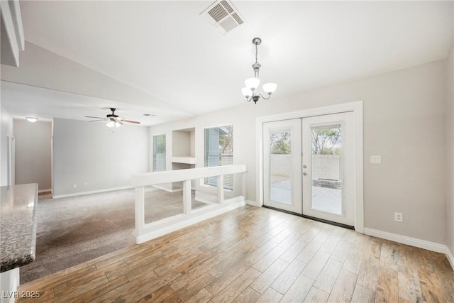 interior space with visible vents, wood finished floors, french doors, and vaulted ceiling