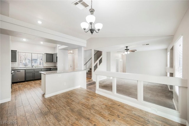 kitchen with visible vents, a kitchen island, lofted ceiling, light wood-style flooring, and gray cabinetry