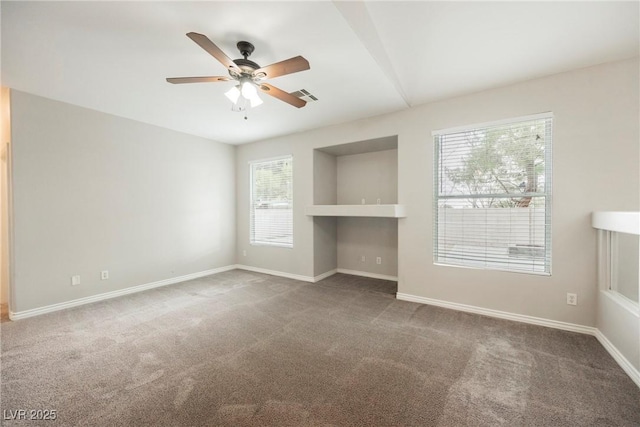 unfurnished room with carpet flooring, baseboards, visible vents, and a ceiling fan