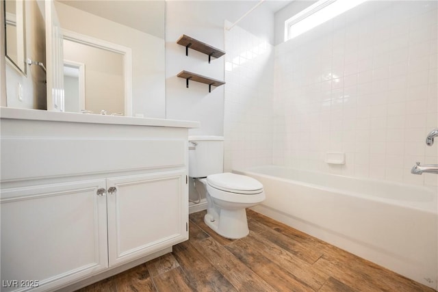 bathroom featuring vanity, shower / bathing tub combination, toilet, and wood finished floors