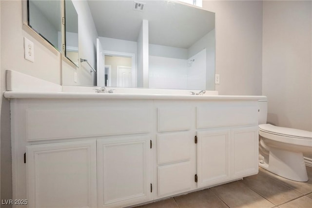 full bathroom featuring visible vents, double vanity, a sink, tile patterned floors, and toilet