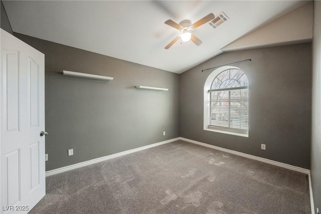 carpeted spare room with visible vents, ceiling fan, baseboards, and vaulted ceiling