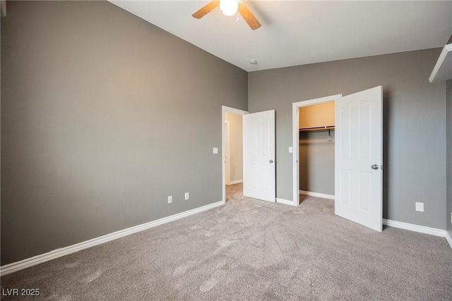 unfurnished bedroom featuring a ceiling fan, a closet, carpet, baseboards, and vaulted ceiling