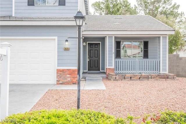 doorway to property featuring a porch, a garage, and brick siding