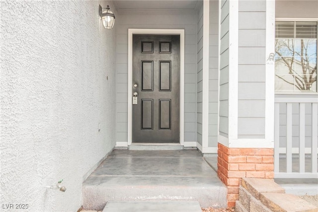 doorway to property featuring stucco siding