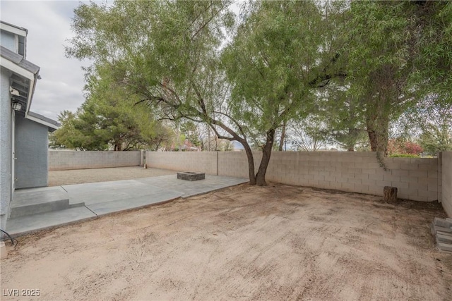 view of yard featuring a patio, a fenced backyard, and a fire pit