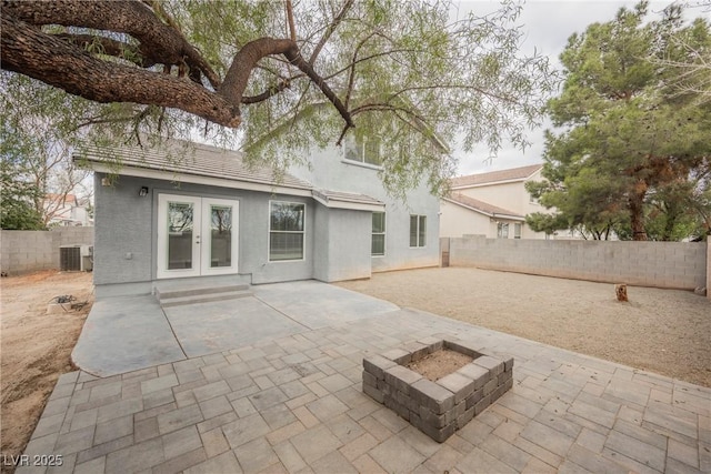 back of house with a fenced backyard, stucco siding, french doors, and a patio