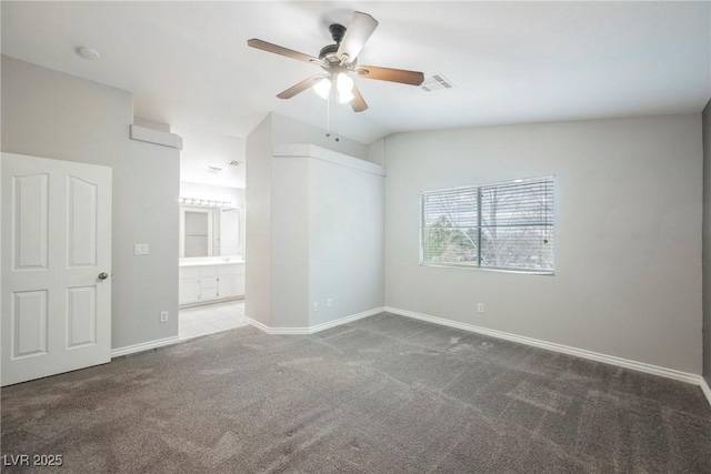 spare room with visible vents, a ceiling fan, carpet floors, baseboards, and vaulted ceiling