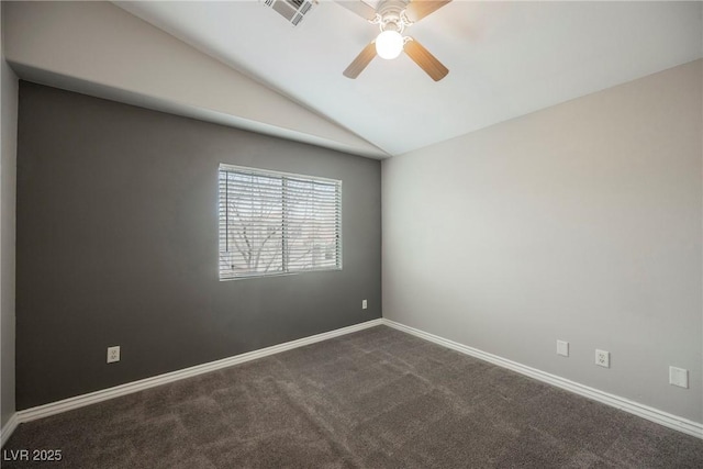 spare room featuring visible vents, ceiling fan, baseboards, dark carpet, and vaulted ceiling