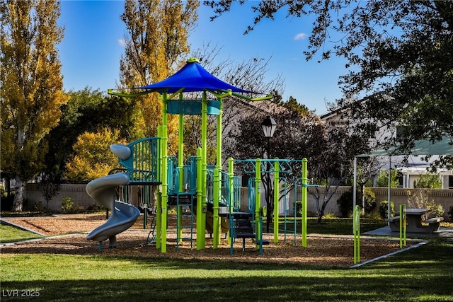 community jungle gym featuring a lawn and fence