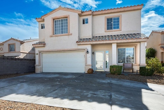 mediterranean / spanish-style home featuring concrete driveway, a tiled roof, a garage, and stucco siding