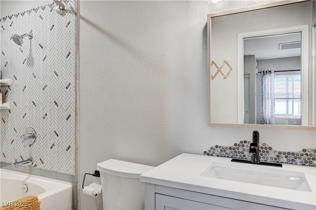 bathroom with visible vents, toilet, bathtub / shower combination, a textured wall, and vanity