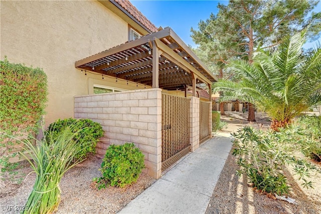 exterior space featuring stucco siding and a pergola