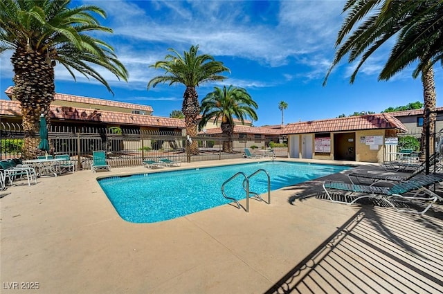 pool with a patio and fence