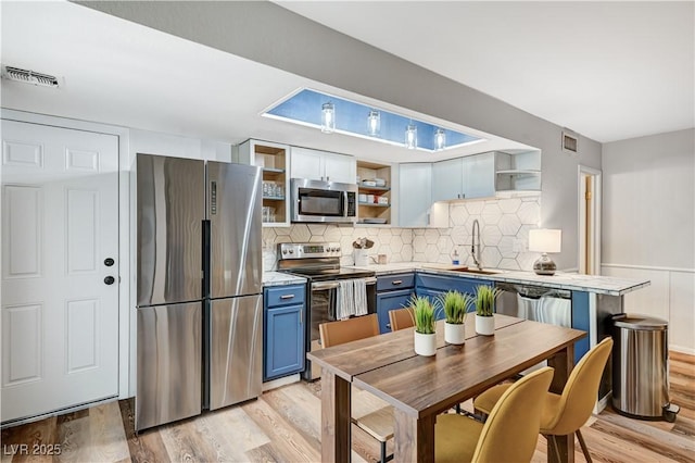 kitchen with open shelves, stainless steel appliances, visible vents, and blue cabinets