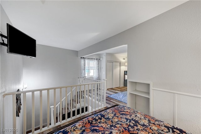 corridor featuring wood finished floors and an upstairs landing