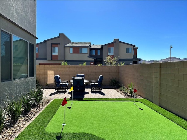 view of yard featuring a patio area, a mountain view, and fence