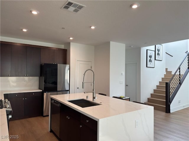 kitchen with light wood finished floors, visible vents, stainless steel appliances, and a sink