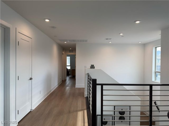 corridor featuring visible vents, an upstairs landing, wood finished floors, recessed lighting, and baseboards