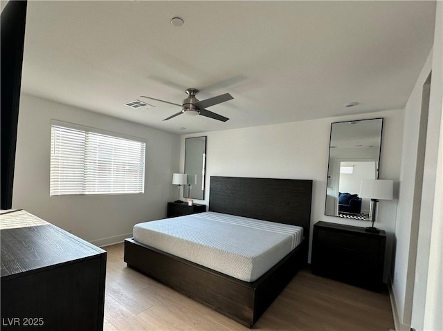 bedroom featuring baseboards, visible vents, light wood-type flooring, and ceiling fan