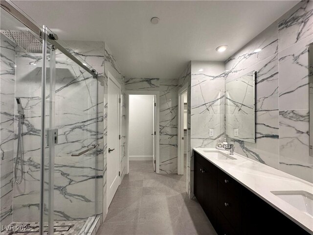 bathroom featuring double vanity, a marble finish shower, and a sink