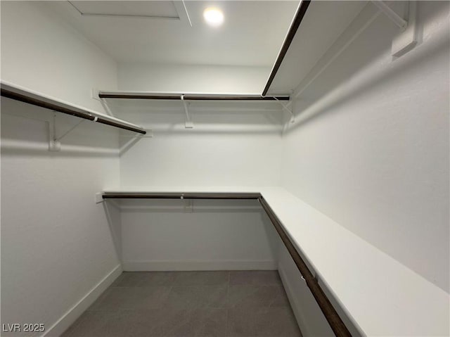 walk in closet with light tile patterned floors