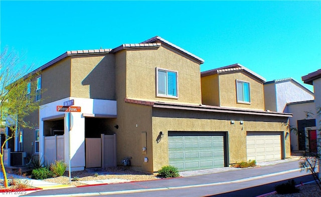 view of front of property with central air condition unit, stucco siding, and an attached garage