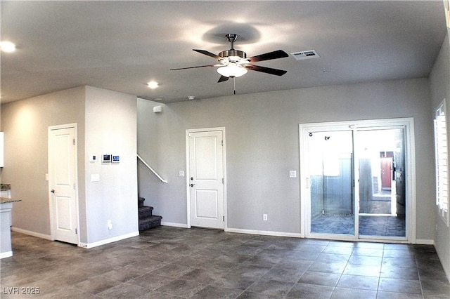 spare room with visible vents, baseboards, ceiling fan, and stairs