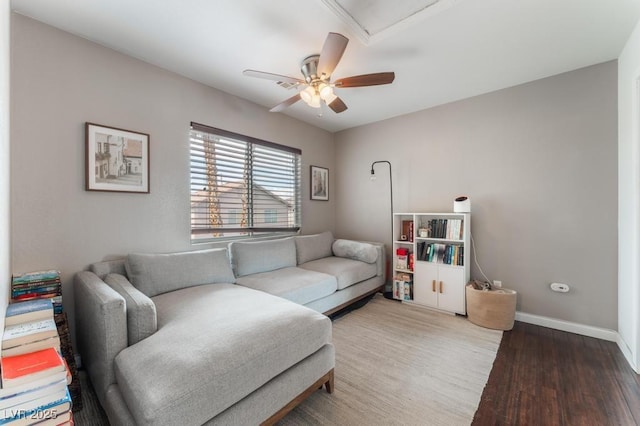 living area featuring ceiling fan, baseboards, and wood finished floors